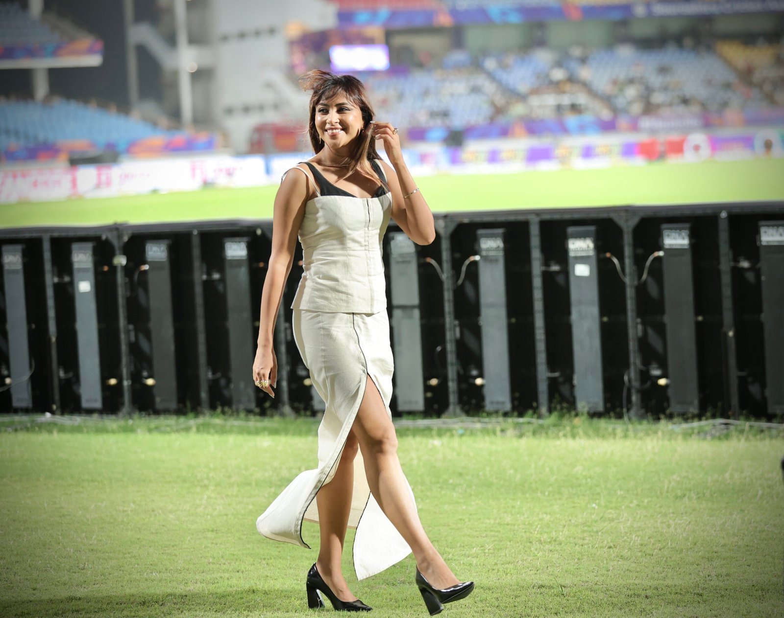 Woman walking confidently on cricket ground – outdoor fashion portrait photography